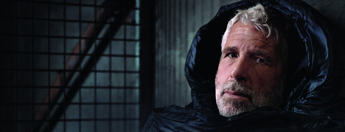 Der Fernsehmoderator Dirk Stermann als Obdachloser im Schlafsack abgebildet