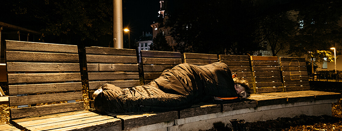Obdachloser Mann in Einkaufsstraße